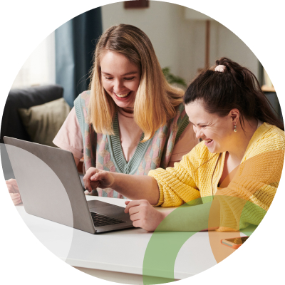 Two ladies sitting at table with laptop