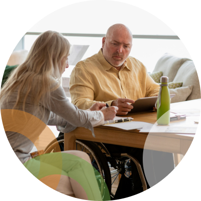 Men and woman sitting at table with tablet