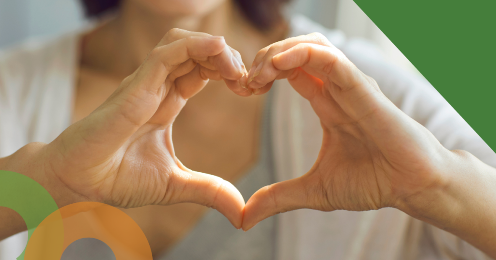 Image for volunteering - shows a woman holding up a heart hand symbol.